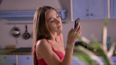 Sutyen manifatura telefon ve mutfak, seksi ve çekici, model kusursuz bir beden ile duran genç güzel kadın