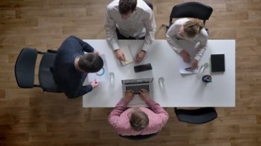 Geldiğin ve belge, dört kişilik ekibin tezahürat ve modern ofisinde otururken, topshot, onların zafer zevk gösteren yönetmen