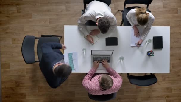 Baas komt en team van vier mensen beginnen vergadering, topshot, zakenmensen plannen nieuw project in moderne kantoren — Stockvideo