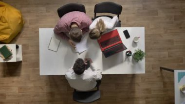Takım gidiyor ve modern ofis masada oturan projesi, topshot, tartışan üç genç iş adamları