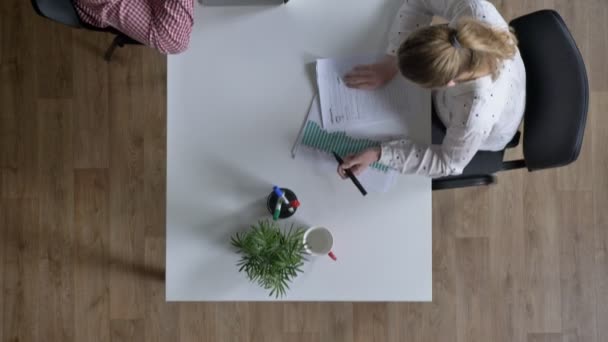 Camera beweegt over mensen uit het bedrijfsleven werken en zitten aan tafel in de moderne kantoor, topshot — Stockvideo