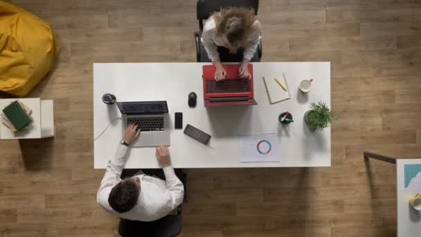 Giovane che lavora in ufficio e che dà documento a collega donna, topshot, concetto di lavoro in testa — Video Stock