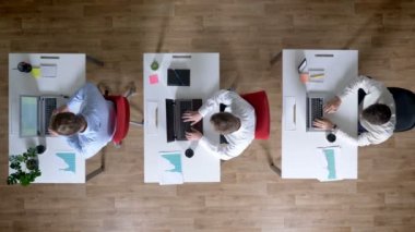 Üç genç işadamı dizüstü bilgisayarlar, işyeri aynı anda bırakarak, iş kavramı, office kavramı, iletişim kavramı, en iyi atış üzerinde çalışıyoruz