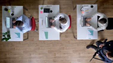 Üç genç işadamı dizüstü bilgisayarlar üzerinde çalışıyoruz, silahı olan adam onları, iş kavramı, office kavramı, sömürü kavramı, en iyi atış kontrol eder