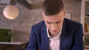 Genç çekici işadamı smartphone ofis, yeşil ekran, gülümseyen, iş kavramı, iletişim kavramı gösterilen izliyor