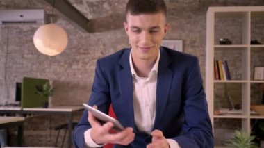 Genç çekici işadamı tablet ofis, yeşil ekran, gülümseyen, iş kavramı, iletişim kavramı gösterilen izliyor