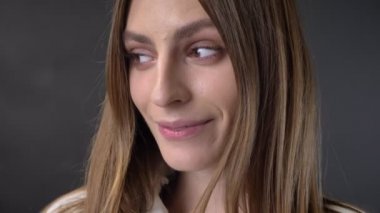 Kavram flört genç çekici kız yüzünü kameraya, izliyor, arka plan gri