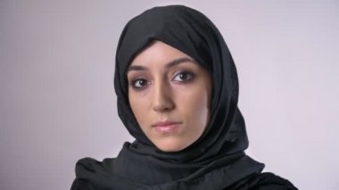Hijab genç ciddi Müslüman kız kameraya, gri arka plan izliyor