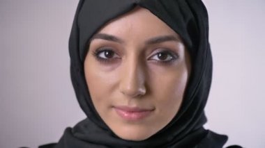 Genç Müslüman kız hijab içinde gözlerini açar ve saatler kamera kavramı, rüya, arka plan gri