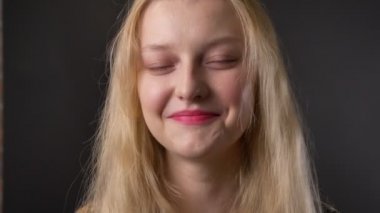 Pembe ruj sevimli sarışın kızla genç gülümseyen, gri arka plan fotoğraf makinesi, izliyor