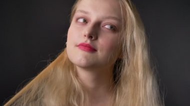 Genç kız pembe ile darbe saçlı, gri arka plan, flipt kavramı ile oynamaya ruj kameraya, izledikten