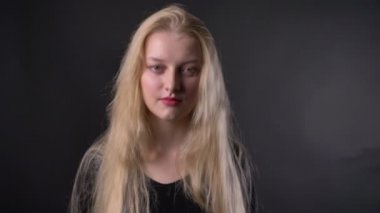 Genç güzel yorgun sarışın kız pembe ruj ile kameraya, gri arka plan izliyor