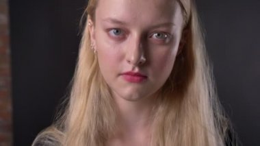 Genç Sevimli sarışın kız pembe ruj ile el yükselterek, kamera, gülümseyen, flört kavramı, izlerken, arka plan gri