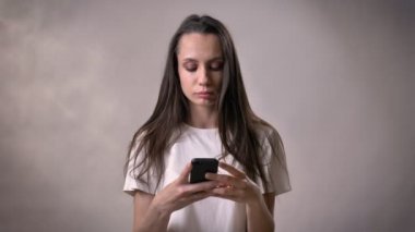 Genç esmer kız yeşil ekran smartphone, işareti, iletişim kavramı, gri arka plan gibi gösterilen