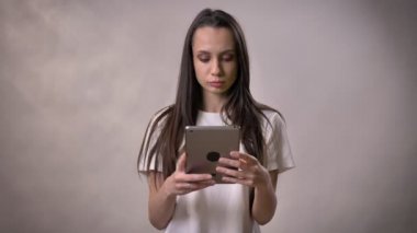 Genç esmer kız yeşil ekran tablet, iletişim kavramı, gri arka planda gösterilen