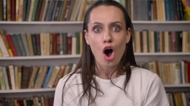 Genç Şirin esmer kız Kütüphane, sürpriz, zafer nedeniyle mutlu duruyor