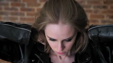 Dumanlı gözler yorgun depresif kızı izlerken kamera, yakında saç, tuğla arka plan