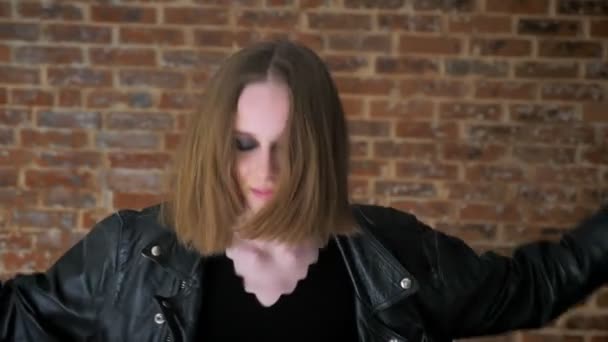 Ung sexig tjej med sotade ögon Dans, skakar huvud, hardcore, tegel bakgrund — Stockvideo