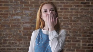 Genç çekici sarışın kız kameraya, izliyor gönderir bir öpücük, flört kavramı, tuğla arka plan