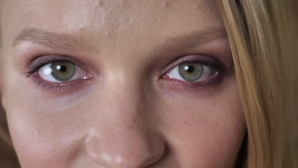 Weit geöffnete Augen von jungen niedlichen blonden Mädchen beobachtet vor der Kamera, Backstein-Hintergrund — Stockvideo