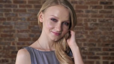 Genç Sevimli sarışın kız birler, flört kavramı, tuğla arka plan