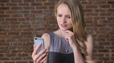 Görüntülü sohbet konuşmak smartphone, iletişim kavramı, tuğla arka plan üzerinde Genç Sevimli sarışın kız s