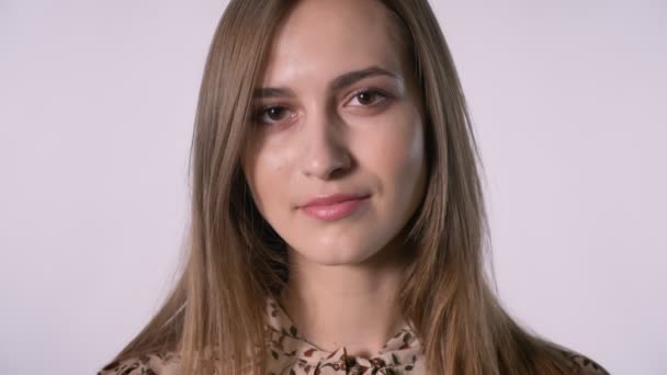 Gesicht der jungen hübschen Frau schaut in die Kamera, weißer Hintergrund — Stockvideo