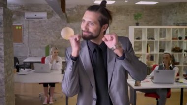 Sakallı neşeli işadamı gülümseyen, arkadaşları ona, iş kavramı izliyor ofisinde, dans ediyor, kavram sakin ol