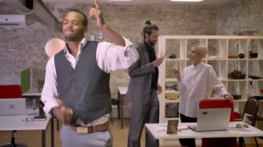 Afrika işadamı ofiste dans ediyor, colleaues champange içme ve konuşurken, kavram, şirket parti konsept rahatla