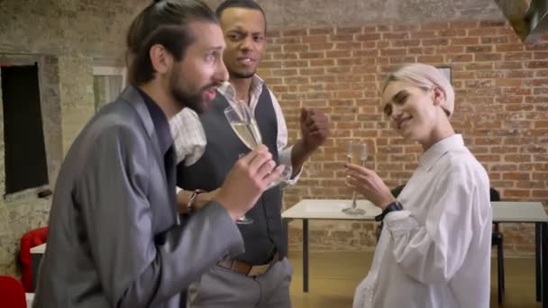 Tre multy-etniska arbetstagare dansande i office, sjunger i glas, dricka champagne, företaget party konceptet — Stockvideo