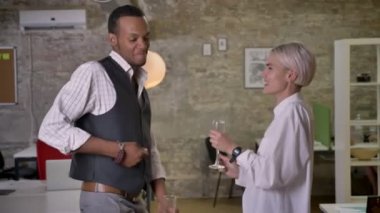 İki multy-etnik işçiler ofiste, Gözlük, şampanya, şirket parti kavramı içki tungur dans ediyor