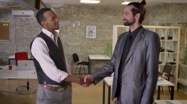 İki multy-etnik işçiler ofiste, gülümseyen, iletişim kavramı elleri titriyor