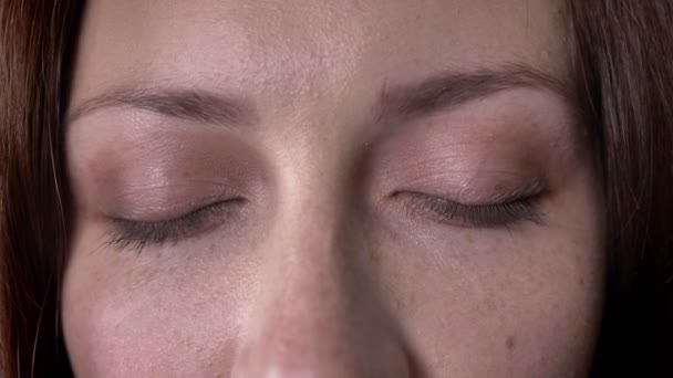 Face of brown hair girl opens eyes, watching at camera — Stock Video