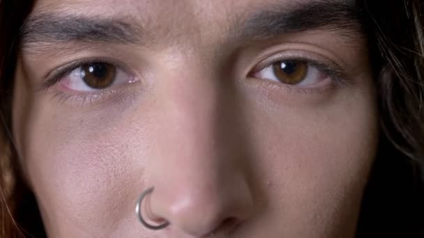 Eeys de tânăr om de păr lung cu inel de nas se uită la aparat de fotografiat, zâmbind — Videoclip de stoc