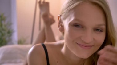 Genç seksi blonda Bayan iç çamaşırı kanepede yatıyor, bacaklarını sallıyor, kavram flört, kavram sakin ol