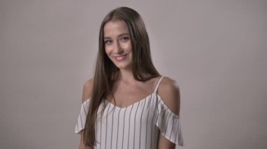 Sevimli Genç kız kameraya, izliyor gülümseyen, saç, arka plan gri