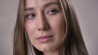 Genç seksi kız kameraya, izliyor gözleri oynarken, kavram, gri arka plan flört