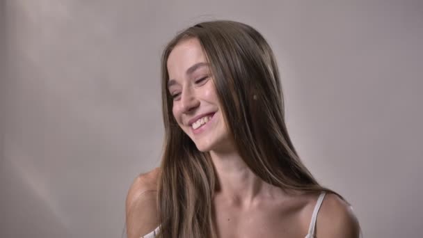 若いセクシーな女の子をカメラで見ている髪、動いて、笑って、浮気の概念、灰色の背景に触れる — ストック動画