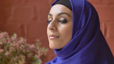 Hijab kameraya bakıyor ve gülümsüyor, güzel mutlu Bayan portresi deldi burun ile genç Müslüman kadın