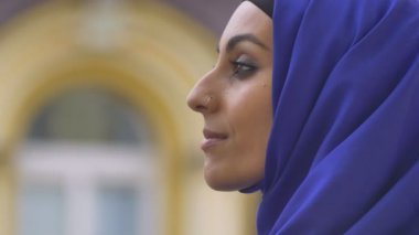 Kameraya bakarak ve gülümseyen, mutlu deldi burun ile genç güzel bir Müslüman kadın portresi