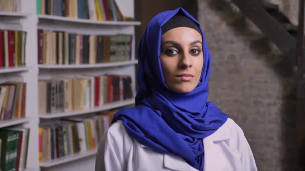 Portré, fiatal szép muszlim nő a hidzsáb látszó-on fényképezőgép, komoly kifejezés — Stock videók