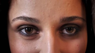 Koyu saçlı güzel kadın gözleri gülümseyerek, kameraya, tuğla arka plan izlerken