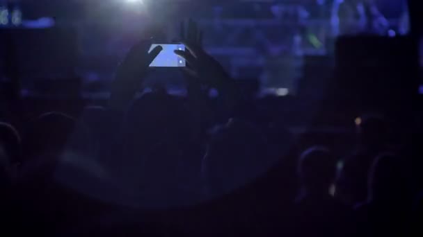 Ruce drží telefon a nahrávání videa na rockový koncert mezi dav — Stock video