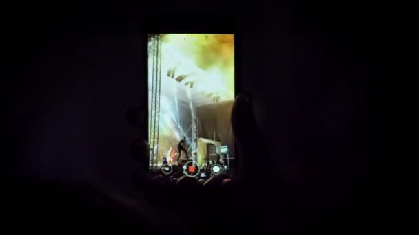 Shot van de hand met telefoon en filmen rockconcert nachts — Stockvideo