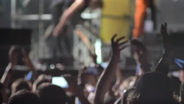 Filmación de la multitud en el concierto de rock por la noche, gente levantando las manos — Vídeo de stock