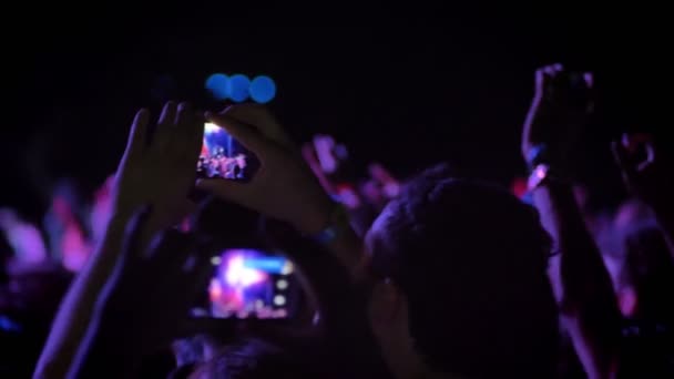 Mann nimmt nächtliches Video bei Rockkonzert auf und steht in Menschenmenge — Stockvideo