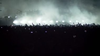 Kalabalık parlak yanıp sönen aydınlatma ile büyük sahne yakınındaki