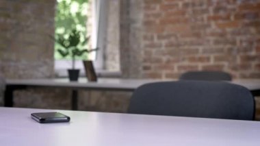 Hareket eden telefon boş modern ofis masasında yatarken