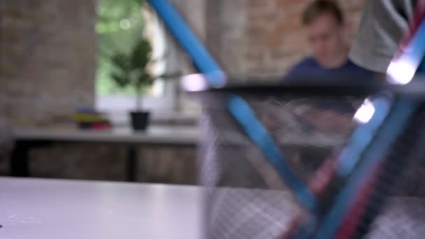 Крупним планом знімок рук чоловіка, що друкується на планшеті і тримає каву в офісі — стокове відео