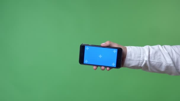 Рука показывает смартфон с хромакеем в камере, фон хромакея — стоковое видео